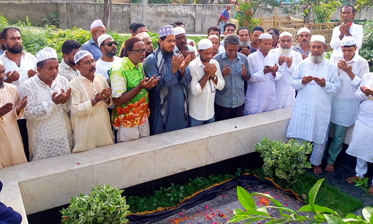 কবরের পাশে দাঁড়িয়ে দোয়া করা হচ্ছে। ছবি- সংগৃহীত