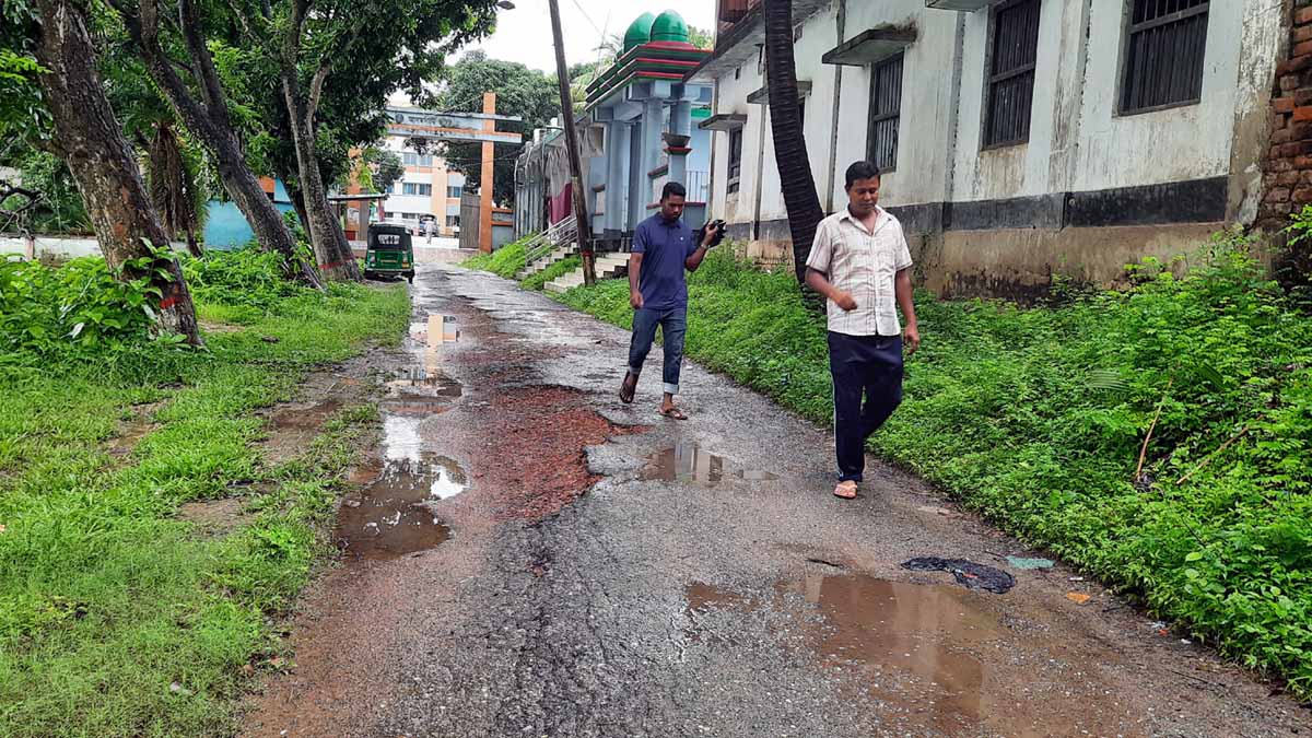 আদমদীঘি থানা গেটের সামনের সড়কে কার্পেটিং উঠে গিয়ে অসংখ্য গর্তের সৃষ্টি হয়েছে। ।      ছবি- রূপালী বাংলাদেশ