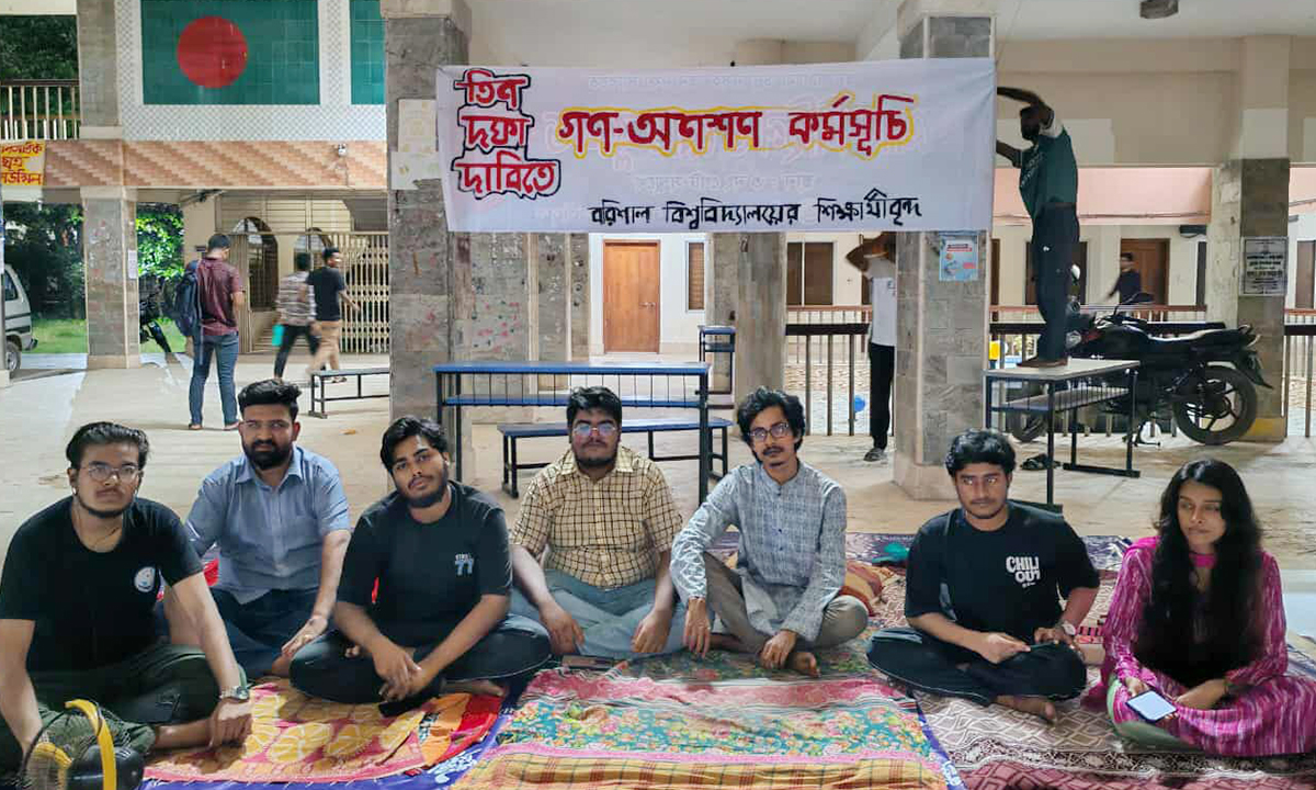 বিশ্ববিদ্যালয়ের প্রশাসনিক ভবন- ১ এর নিচে গণঅনশনে বসে আন্দোলনকারী শিক্ষার্থীরা। ছবি- রূপালী বাংলাদেশ