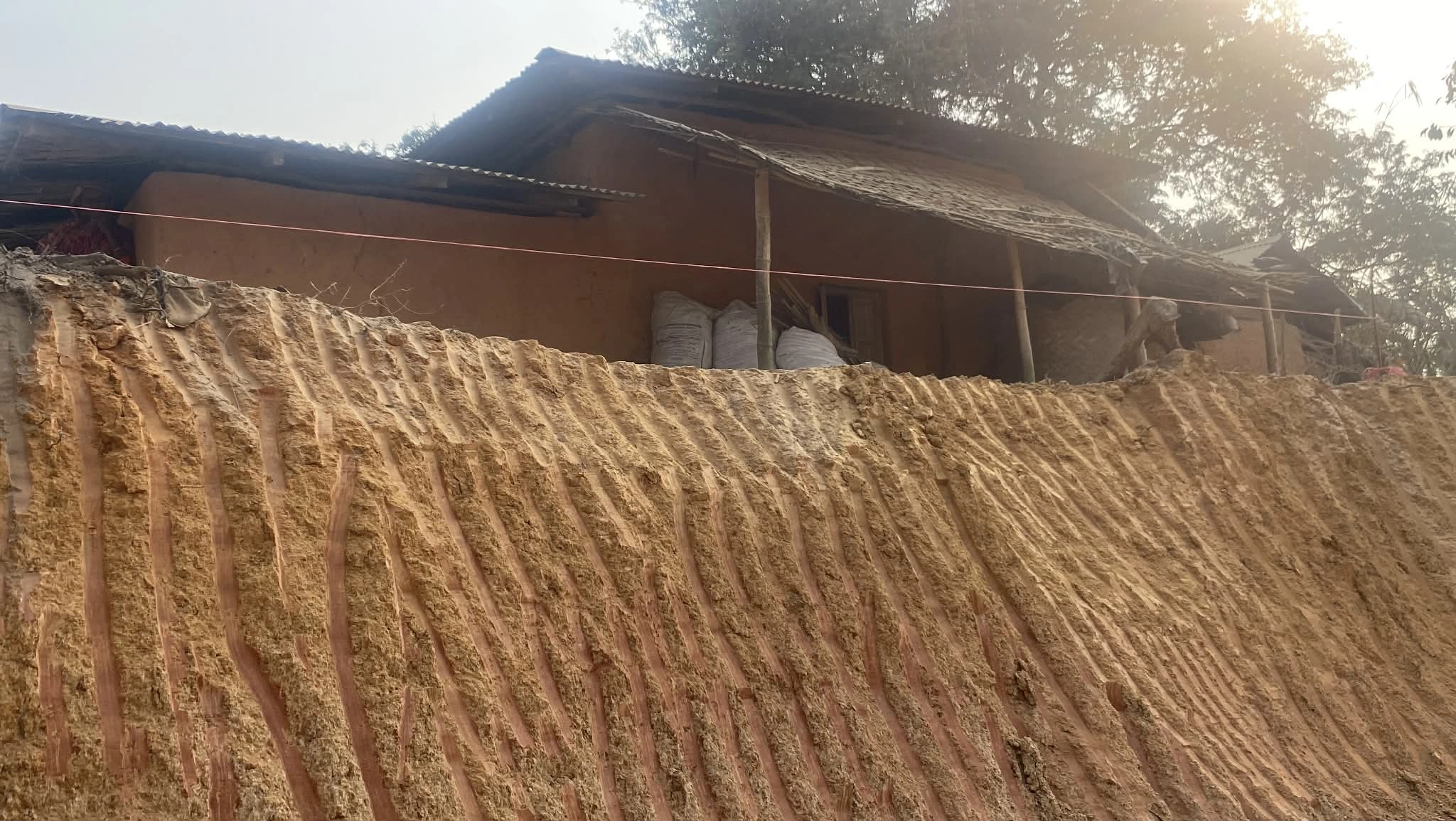 পাহাড় কেটে মাটি নিয়ে যাওয়ার কারণে ধসে পড়ার ঝুঁকিতে থাকা বসতঘর। ছবি : রূপালী বাংলাদেশ