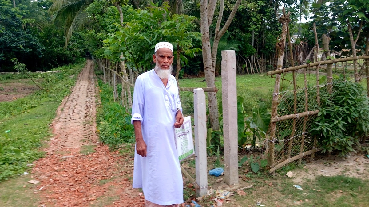 অবসরপ্রাপ্ত কৃষি কর্মকর্তা নুরুল ইসলাম আকন তার জমির সামনে। ছবি : রূপালী বাংলাদেশ