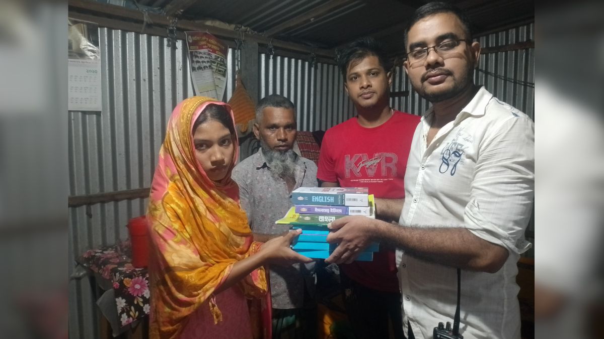 শিক্ষার্থী সুরাইয়া আক্তারের হাতে বই তুলে দেওয়া হয়। ছবি- রূপালী বাংলাদেশ