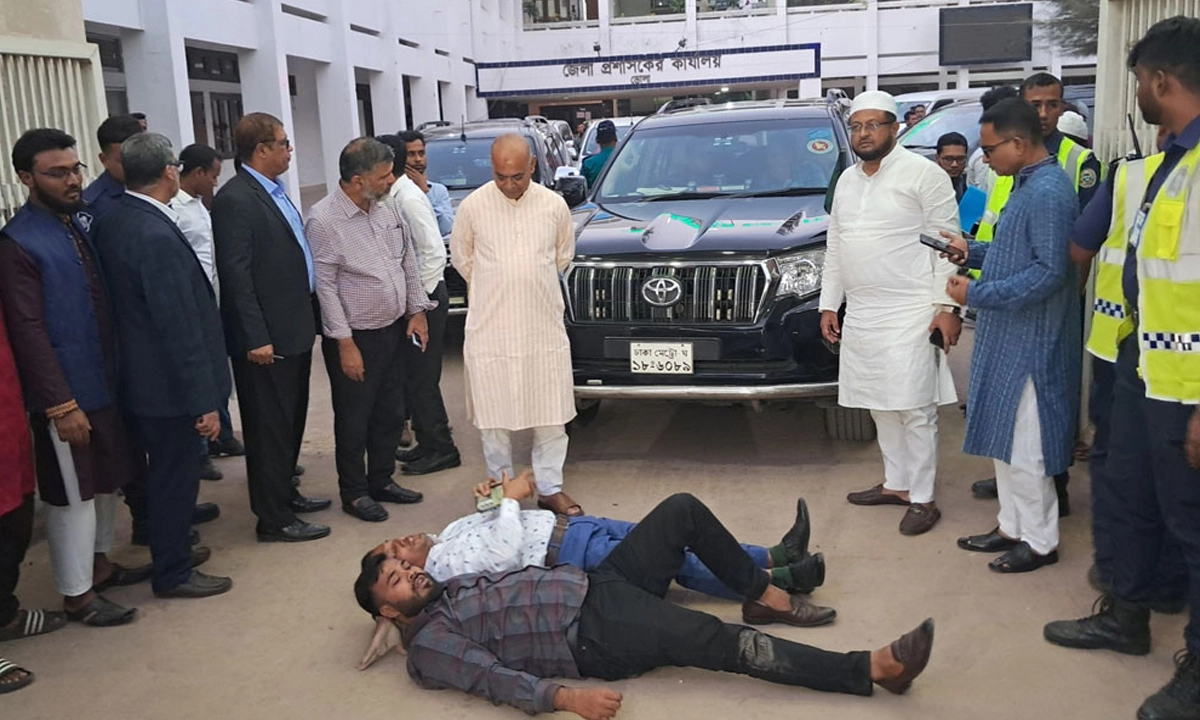জেলা প্রশাসক কার্যালয়ের সামনে তিন উপদেষ্টার গাড়ীর সামনে শুয়ে প্রতিবাদ জানান স্থানীয় জনতারা।  ছবি- সংগৃহীত